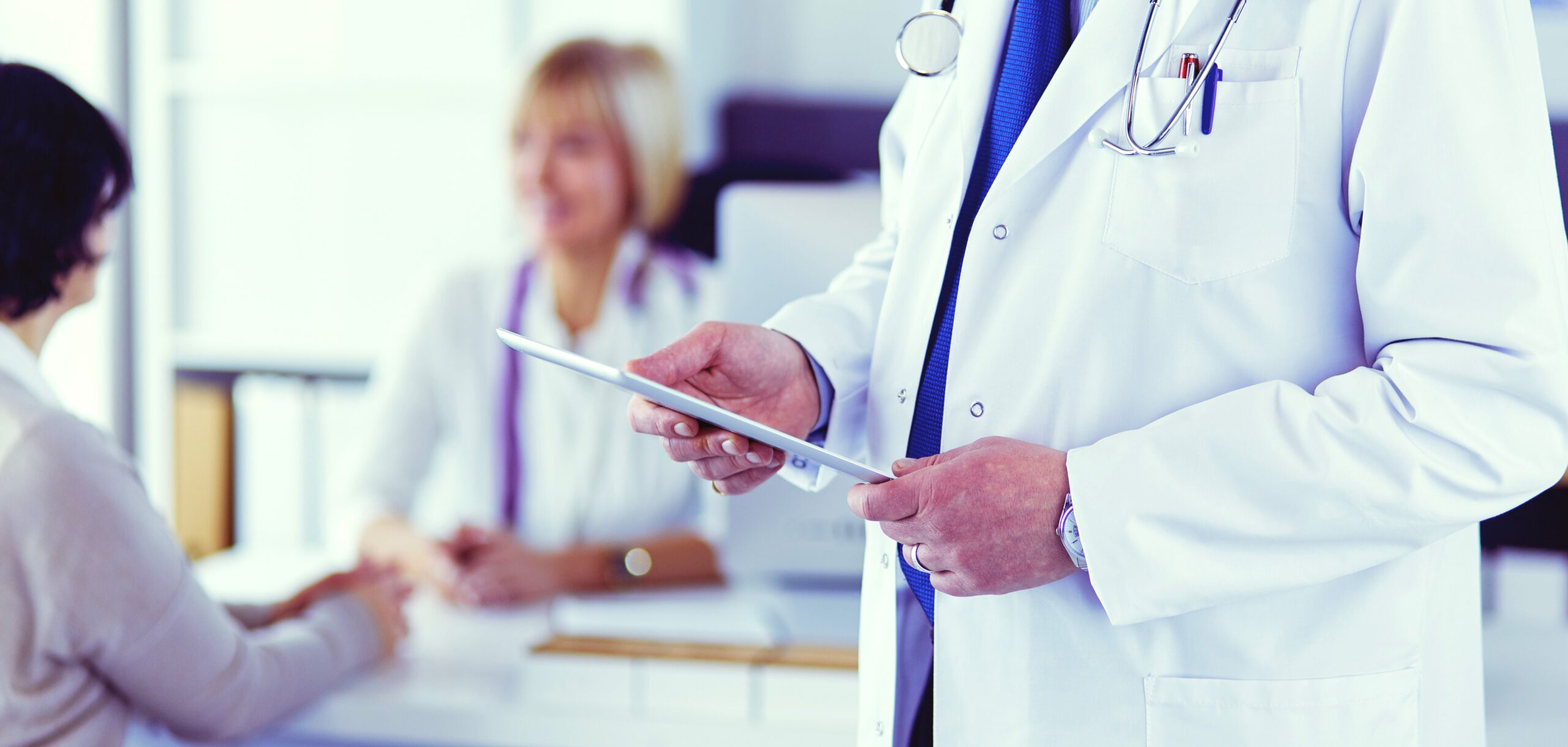 Portrait of senior doctor in office sitting at the desk